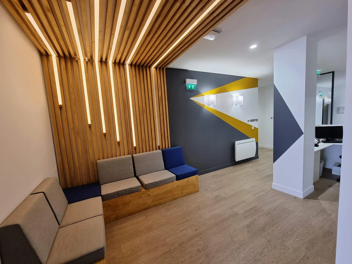 Accueil de l'IPO — salle d'attente principale avec assises design et mur graphique